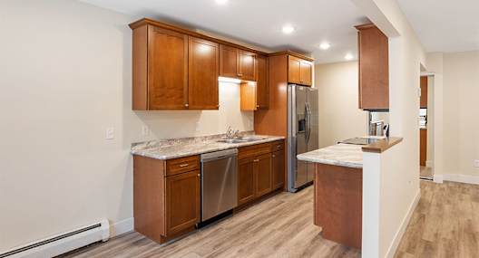 A kitchen with wooden cabinets and a marble countertop.