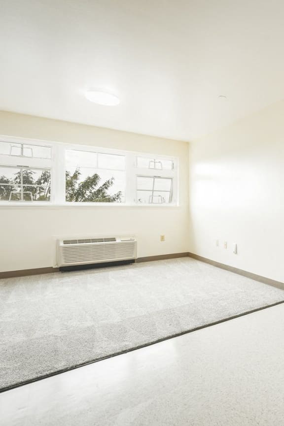 the living room and entrance of an empty house with white walls
