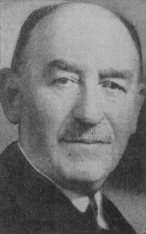 a black and white photo of a man wearing a suit and tie