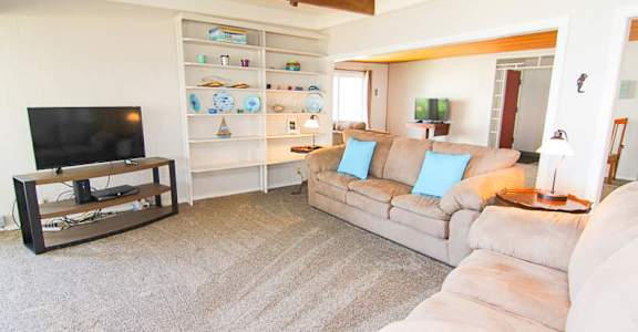 A living room with a grey sofa and a television.