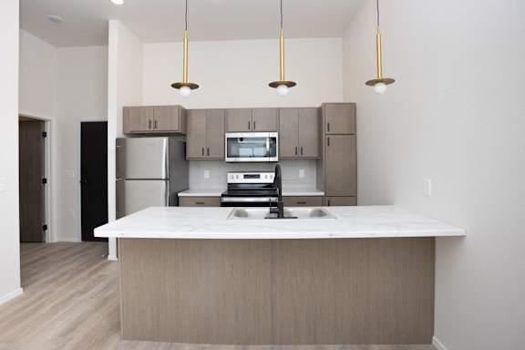 A kitchen with a white counter top and wooden cabinets.