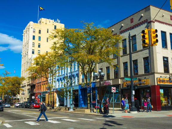 a man crossing the street in front of a building at Beekman on Broadway, Ann Arbor, MI