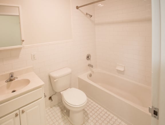 Bathroom with white cabinets and white tile floors