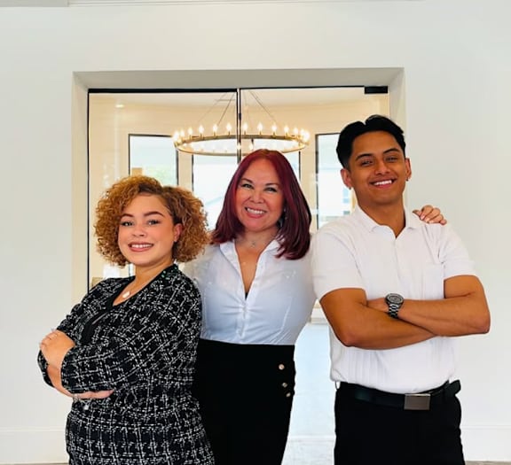 Three people posing for a photo in a room.