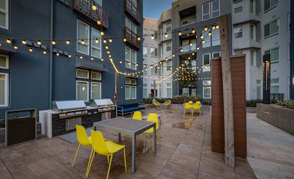an outdoor patio with tables and chairs and string lights