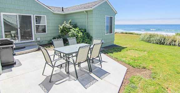A patio with a table and chairs is set up outside a house.