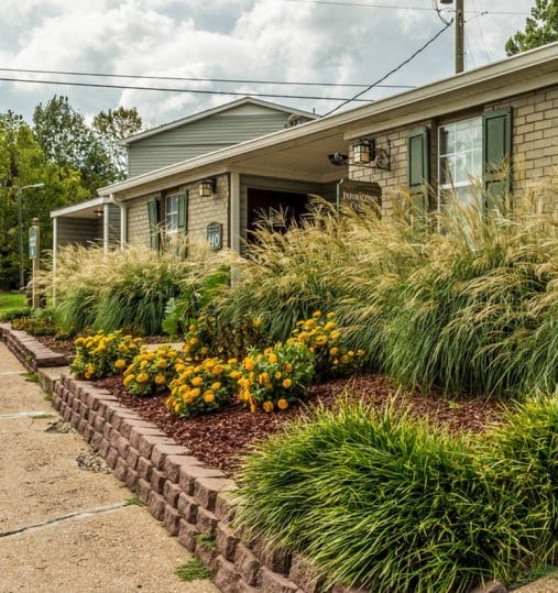 the front of a house with a garden in front of it