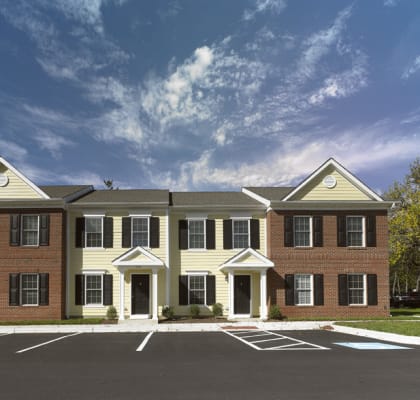 a rendering of a three story apartment building with a parking lot in front of it