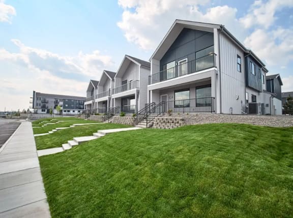 A modern house with a well-maintained lawn in front.