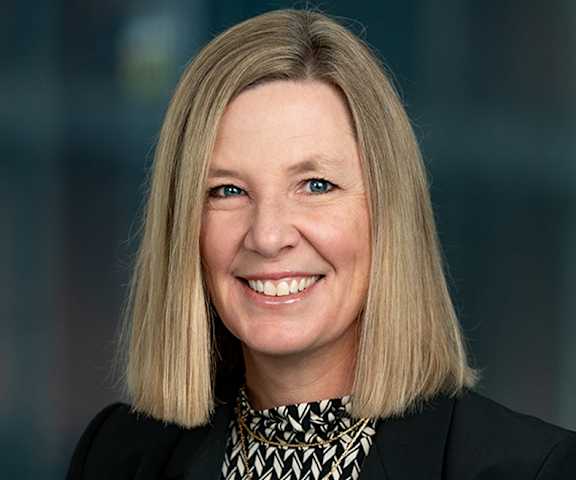 A woman with blonde hair and a black and white patterned collar.