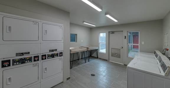a laundry room in a building with washes and dryers