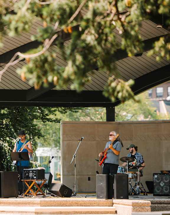 A band performing on a stage under a canopy.