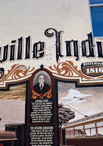 A mural on a building in Fortville Indiana shows a train and a trolley.
