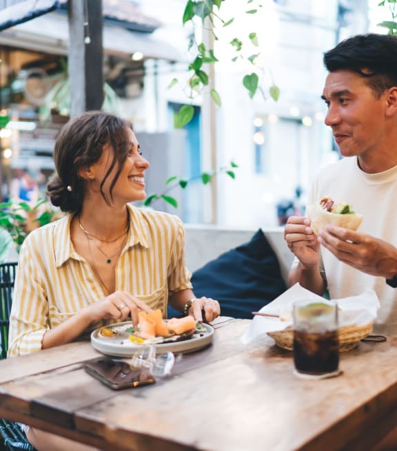 a man and a woman sitting at a table eating food