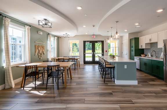 a clubroom kitchen with a large table and chairs at Edgebrook Residences, Merrimack
