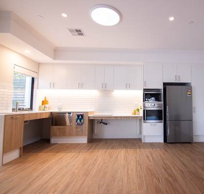 A kitchen with a refrigerator, a table, and a counter.