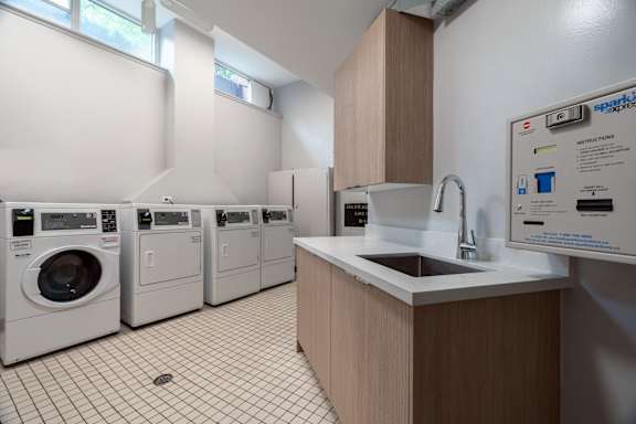 A laundry room with washers and dryers and a sink.at 161 St. George, California, M5R 2M3