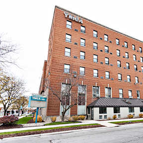 A tall red brick building with the word "YMCA" on the top.
