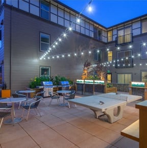 an outdoor patio with tables and chairs at night