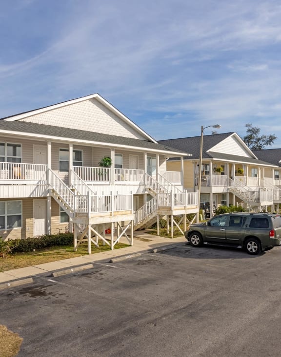 a row of houses with cars parked in front of them