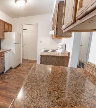 a kitchen with wooden cabinets and granite counter tops