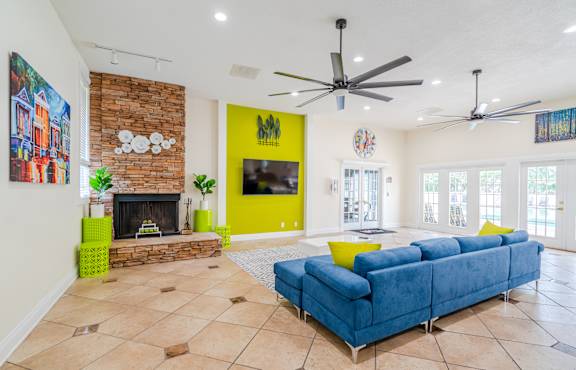 A living room with a blue couch and a fireplace.
