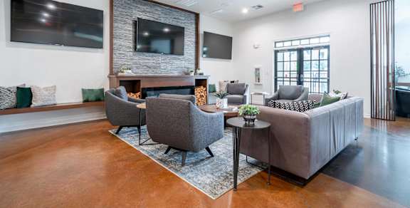 a living room with couches and chairs and a television
