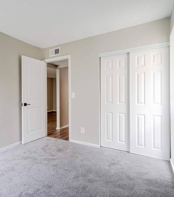 A room with a desk, drawers, and a clock on the wall.