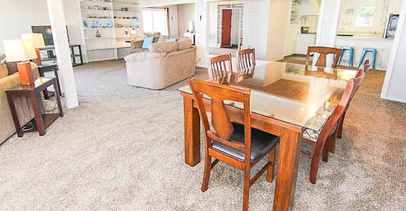 A dining room with a wooden table and chairs.
