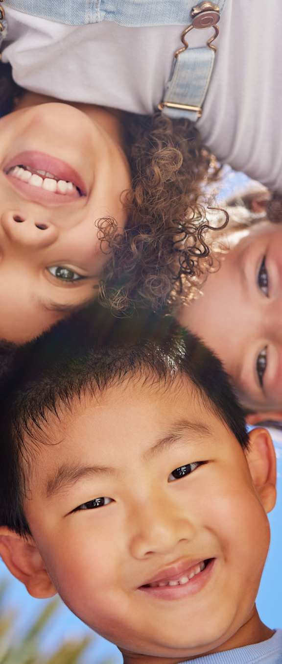 A group of children are standing together in a circle.