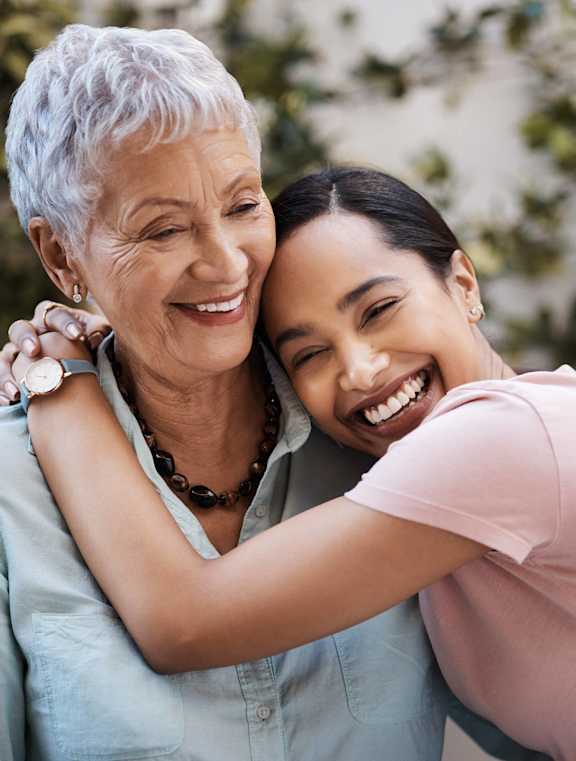a young woman hugging an older woman and smiling