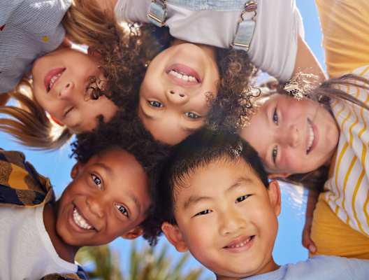 A group of children are standing together in a circle.