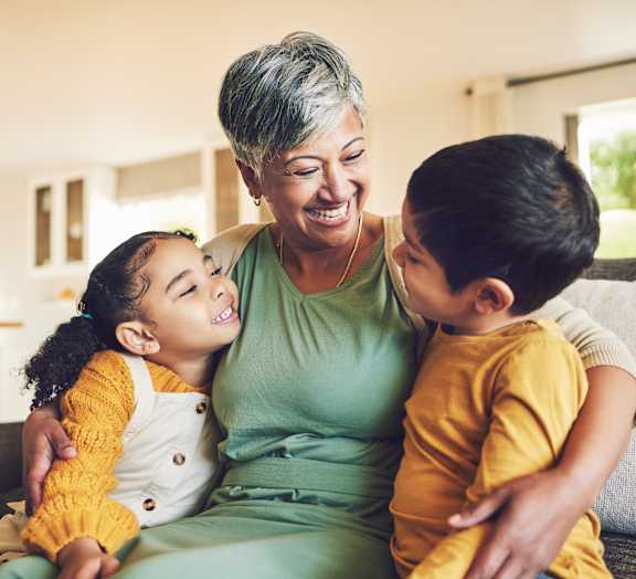 A woman with two children sitting on a couch.