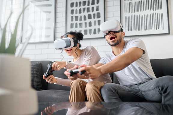 Two people wearing virtual reality headsets and holding controllers