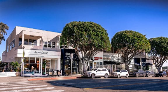 a city street with cars parked in front of a building