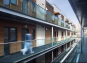 Thumbnail 1 of 4 - a person walking on a balcony of a building