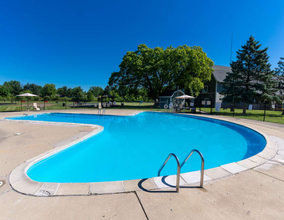 a swimming pool at a park with a building in the background