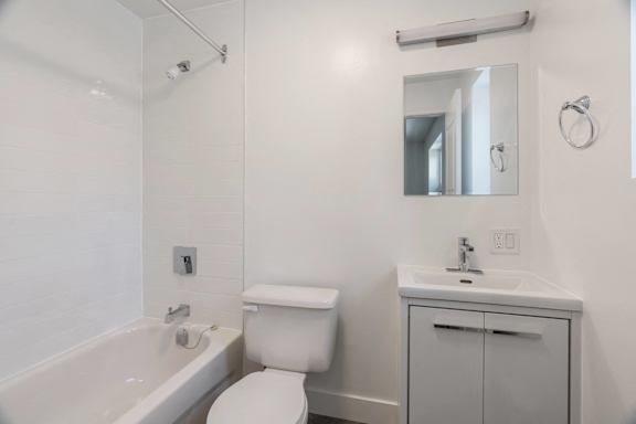 A white bathroom with a toilet, sink, and bathtub. at 608 Church Apartments, Toronto, ON, M4Y 2E7