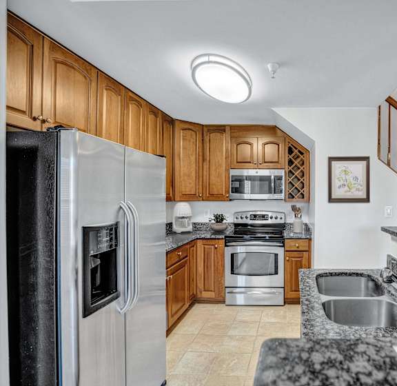 Kitchen with Wooden Cabinets at The Cosmopolitan at Lorton Station in Lorton, VA