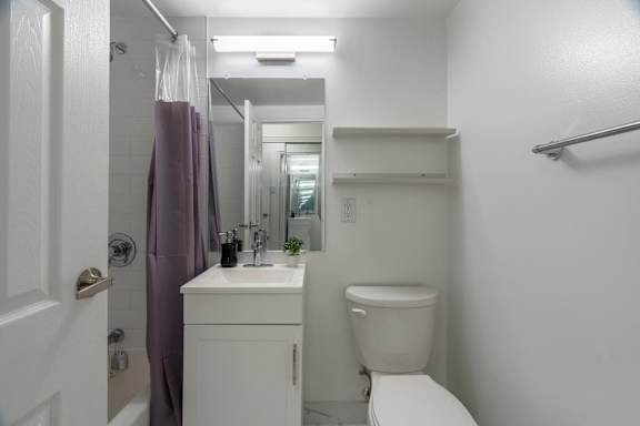 A white bathroom with a toilet, sink, and shower. at 177 Saint George in Toronto, CA