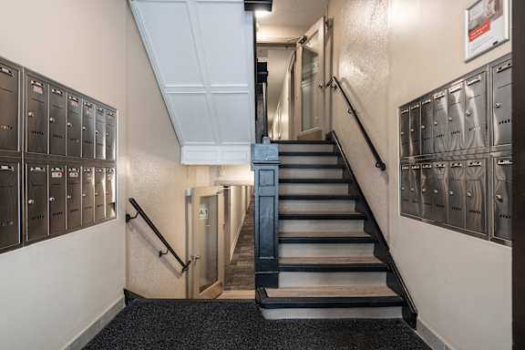 A staircase with a metal railing and a black carpeted floor at 391 Sherbourne Apartments, Ontario