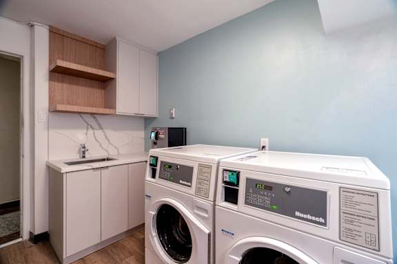 A pair of front loading washing machines in a laundry room.at 111 Cosburn, Ontario, M4J 2L1