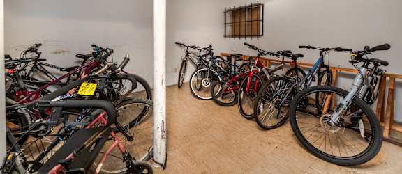 A room full of bicycles with a white pole in the middle.