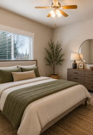 A bedroom with a bed, nightstand, and a ceiling fan.
