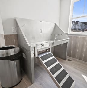 a stainless steel sink in a bathroom with a trash can