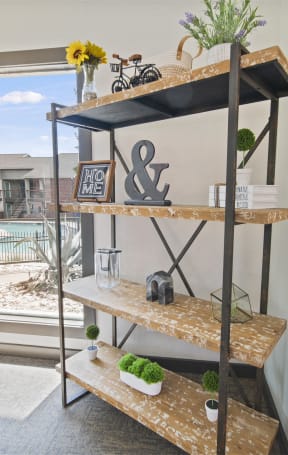 a shelving unit in a living room next to a window