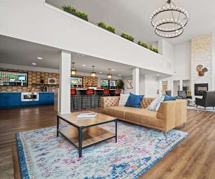 A living room with a blue rug and a wooden coffee table.