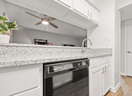 a kitchen with an island and a ceiling fan