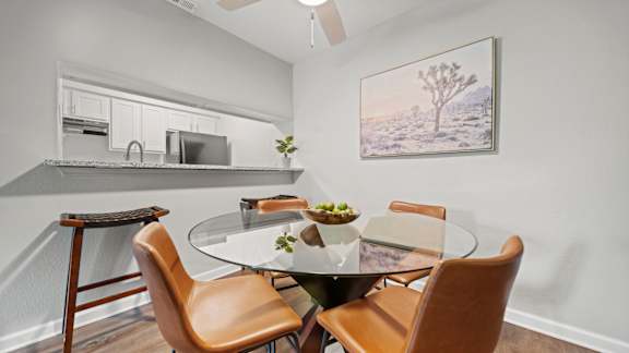 A dining room with a glass table and chairs.