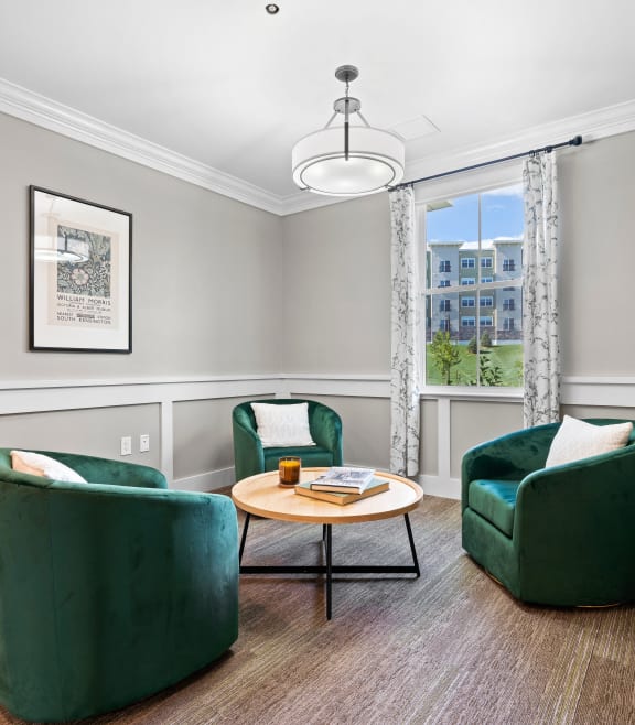 a living room with two green chairs and a table at Edgebrook Residences, Merrimack, 03054